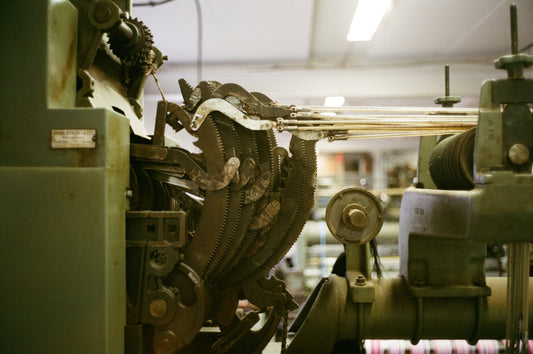 Close-up of an industrial weaving loom in operation.