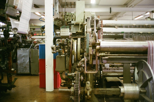 Industrial weaving loom with fabric on a roll.