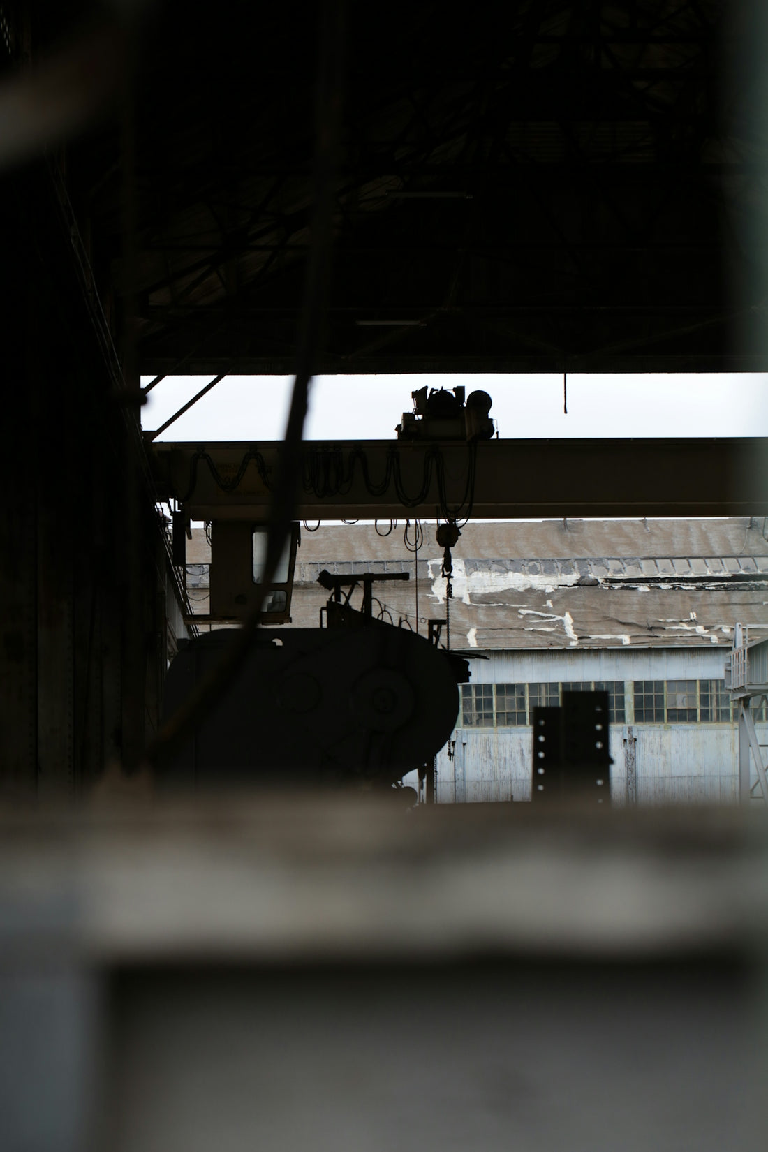 Industrial crane and factory buildings viewed through window