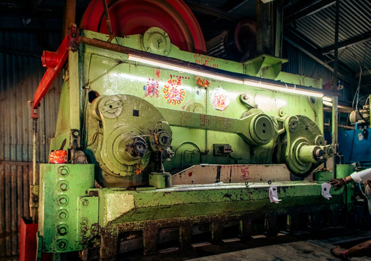 Large industrial metal shearing machine in a workshop.