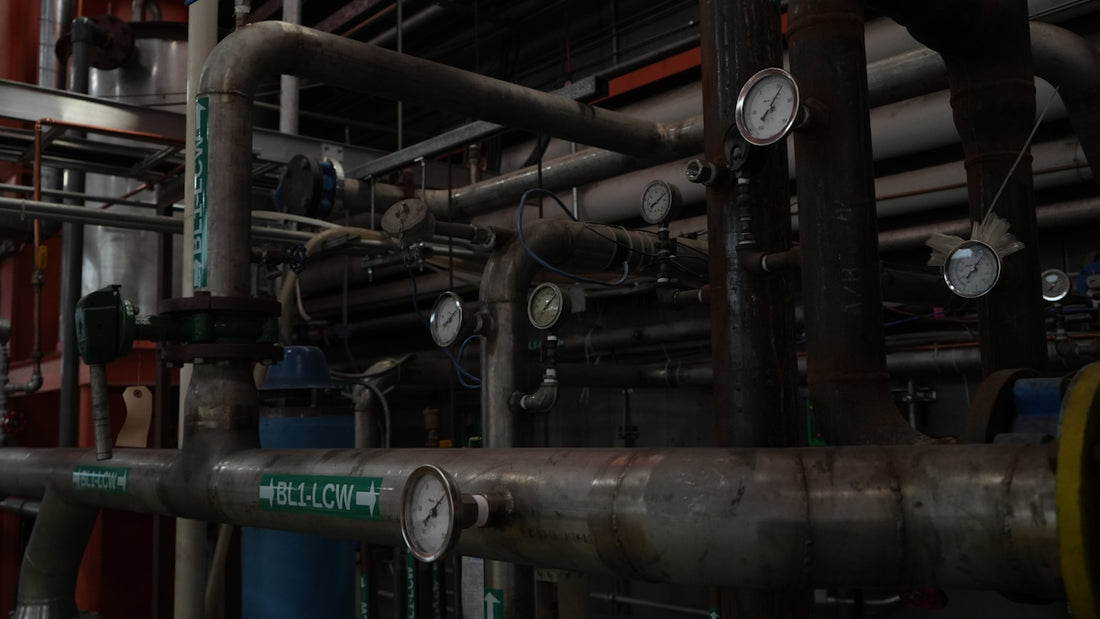 Network of industrial pipes, valves, and gauges.