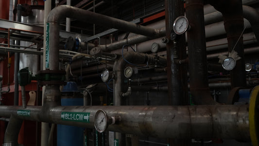 Network of industrial pipes, valves, and gauges.